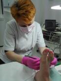 Kobieta badająca stopę pacjenta